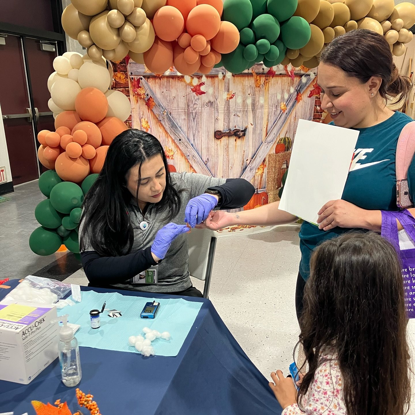 A nurse performing a blood-glucose screening at a CFF community health event